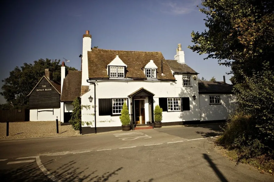 The Holly Bush seen from Potterscrouch Lane, white walls under a tiled roof.